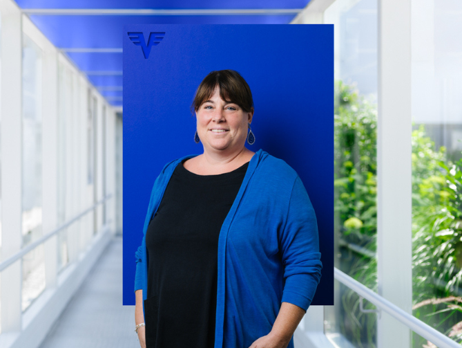 Stephanie Gfrerrer-Knirsch vor blauem Hintergrund.