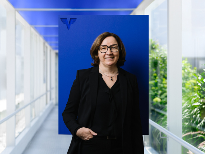 Karin Eichinger auf blauem Hintergrund.