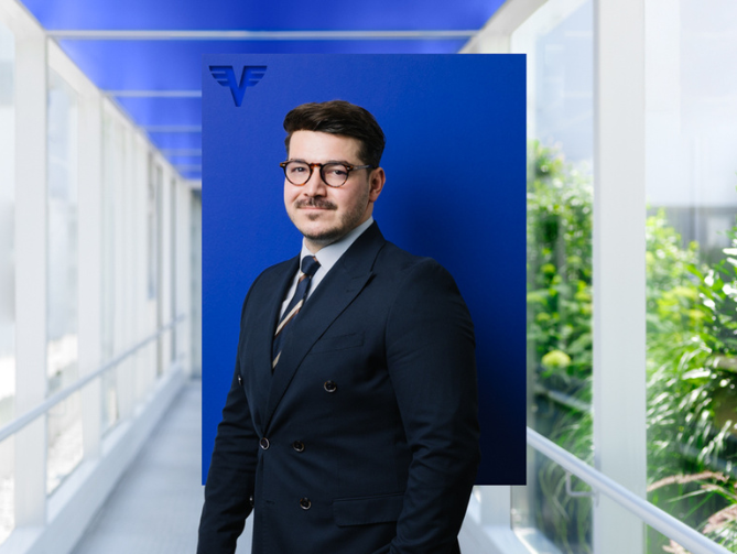 Abdullah Öztürk auf blauem Hintergrund.