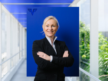 Mag. Petra Schreiber auf blauem Hintergrund.