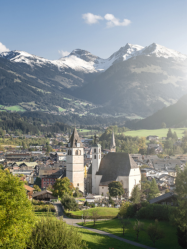 Ein Ort in Tirol, im Hintergrund verschneite Berge.